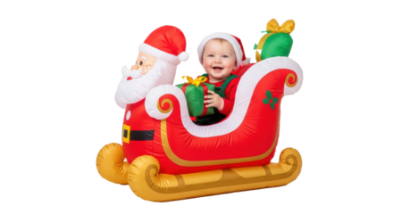 A cheerful baby in santa hat rides in inflatable santa sleigh holding a present and smiling widely