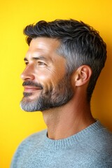 Obraz premium Visual idea of style for aging men. Chic men's crew cut haircut - midlife white man with hair. A handsome man in his 40s with a radiant smile. Yellow solid background.