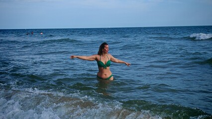 Young Woman Enjoying the Waves in the Sea on a Sunny Day