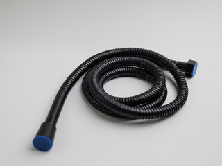 Black jet shower and stainless steel hose on white background