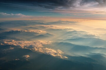 Obraz premium Mountains emerge from a sea of mist, bathed in the warm light of sunrise or sunset.