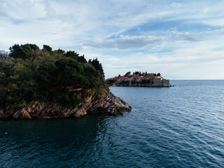 Naklejka premium Aerial view of island hotel connected by causeway to coastal village in Montenegro on Adriatic Sea. c.