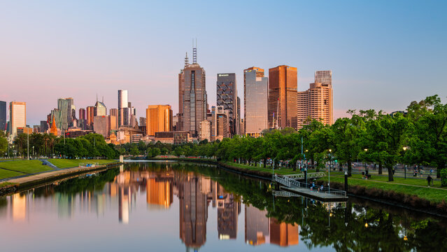 Sunrise on the city buildings of downtown Melbourne, Victoria, Australia as reflected in the calm water of the Yarra River on a perfect Spring morning.