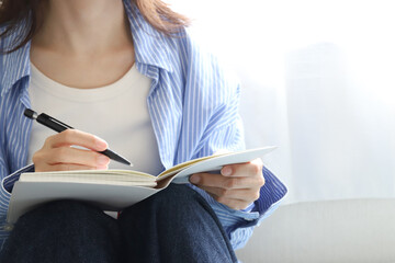 手帳とぺんを持った女性