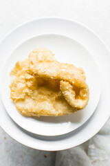 Overhead view of dublan northern nigerian snack, top view of dublan on a plate, flaky fried dough coated in syrup and sesame