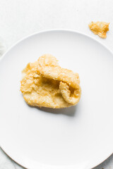 Overhead view of dublan northern nigerian snack, top view of dublan on a plate, flaky fried dough coated in syrup and sesame