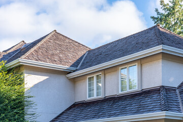 Top of luxury house with shingle roof, green trees and nice windows in Spring in Vancouver, Canada, North America. Day time on May 2025.