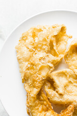 Overhead view of dublan northern nigerian snack, top view of dublan on a plate, flaky fried dough coated in syrup and sesame