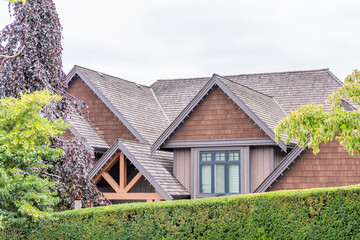 Top of luxury house with shingle roof, green trees and nice windows in Spring in Vancouver, Canada, North America. Day time on May 2025.