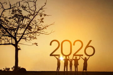 Silhouette of people holding up the year 2026 at a beautiful sunset.