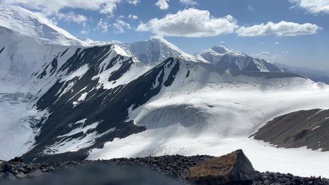 Incredible wide angle running clouds timelapse over Pamir mountains shooted from 5150m Yuhin peak with Krasin peak and Pik Dzerzhinskogo 6717m on Background. Beauty in Nature and extreme sport concept
