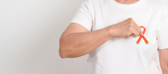 Elderly with Orange Ribbon for September Leukemia, March Kidney cancer day, Multiple Sclerosis, November Complex Regional Pain Syndrome, CRPS, COPD, Chronic Obstructive Pulmonary disease concepts