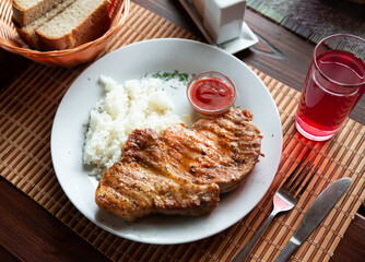 Appetizing roasted pork steak served with boiled rice and sweet and sour dipping sauce