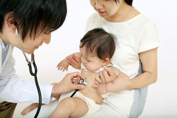 お母さんに抱かれ、聴診器で診察される赤ちゃん