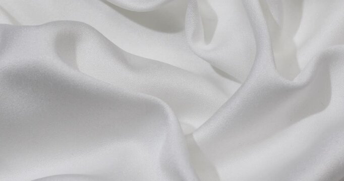 White fabric background. White cloth waves background texture. White fabric cloth textile material.