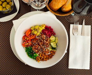 Poke bowl with salmon, avocado, wakame seaweed, fried onion closeup