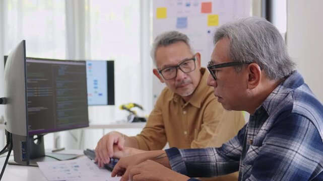 Group of asian senior in a collaborative software development analyzing  flowcharts  during a bootcamp training