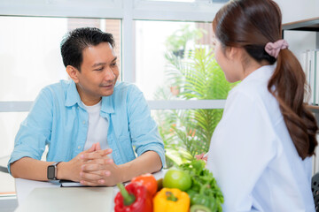 Asian nutritionist using tablet to explaining personalized meal plan with AI to patient during healthcare consultation, healthy lifestyle, woman dietitian showing nutrition plan with AI on tablet.