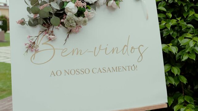 elegant welcome sign with floral decor saying bem vindos ao nosso casamento in portuguese