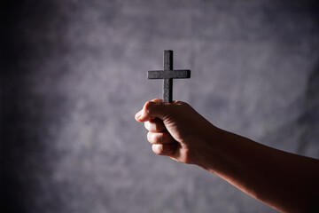 Christian woman lifts her hand in worship to pray, hope, faith, and deep belief in God defines core...