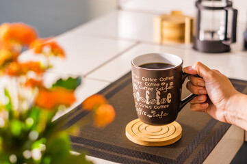 Hand holding a coffee mug with the words Coffee Life on it