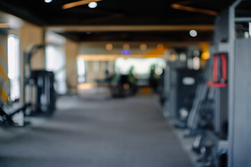 Blurred view of various exercise machines in a modern gym setting. Ideal for backgrounds or illustrating fitness and healthy lifestyle concepts.