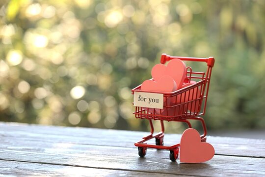 Miniature shopping cart filled with pink hearts and a for you tag
