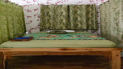 Massage bed with towels, oil, and neck cushion in a curtained spa room, ready for relaxation,...