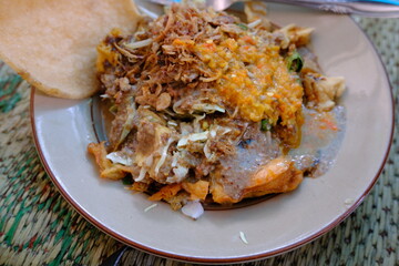 Top-down view of Tahu Gimbal, a traditional Semarang dish made with fried tofu, prawn fritters, peanut sauce, and vegetables.