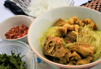 Soto is traditional food asian. Soto on white bowl dish for lunch, dinner in restaurant. Soto with chicken meat,vegetable,soup,sauce the tasty very delicious meal. Fresh hot Soto is healthy food