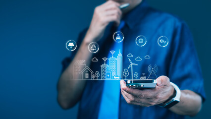 Businessman analyzing eco smart city icons on smartphone for green technology integration and urban real estate innovation