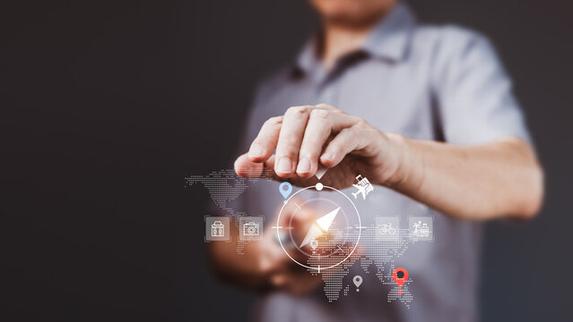 Businessman using virtual compass with travel icons over world map for smart global tourism navigation and route planning