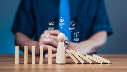 Business resilience and stability concept with wooden figure resisting falling dominoes and icons for innovation and decision-making