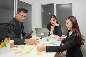 Young happy asian business man and woman work together. Creative team brainstorm meeting. Businesspeople colleague partnership or office coworker teamwork concept