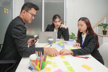 Young happy asian business man and woman work together. Creative team brainstorm meeting. Businesspeople colleague partnership or office coworker teamwork concept