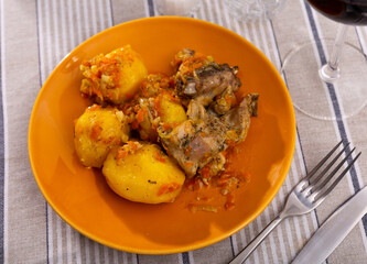 Grilled rabbit leg quarters served on plate with boiled potatoes