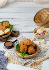 Steamed dimsum food with chili sauce with a brown wood and white wood background