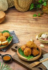 Steamed dimsum food with chili sauce with a brown wood and white wood background