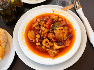 Portion of soup - stewed tripe with chickpea is cooked in plate - stomach of cattle. Traditional dish of Russian cuisine made from offal and offal of cow