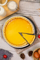 Large round milk pie with fresh and sweet fruit topping, white wooden background