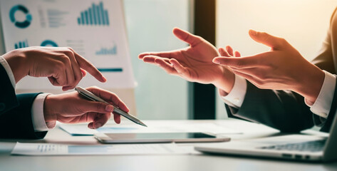 Business meeting with hands pointing at documents and gesturing in discussion, emphasizing key points and exchanging insights in a dynamic collaboration environment focused on planning.