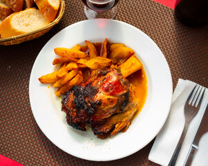 Appetizing braised pork knuckle served with garnish of crispy french fries