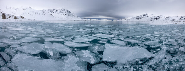 High resolution panorama - Floating ice on the ocean with mountains in the background before a storm in the arctic of Svalbard, Norway