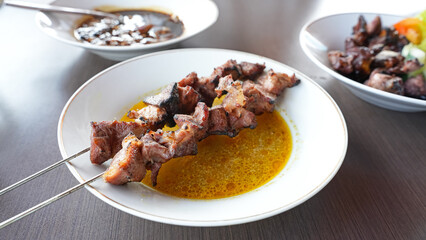 Sate Klatak, tender lamb satay skewered on bicycle spokes, served on yellow curry soup. Popular street food in Yogyakarta
