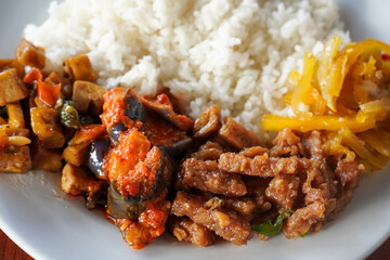 **Nasi Rames, Indonesia, captured on August 6, 2025. Mixed rice dish with assorted side dishes like tempeh, vegetables, sambal, and curry, showcasing a colorful and flavorful everyday Indonesian meal