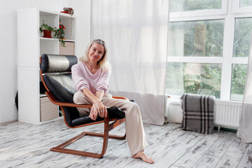 Fototapeta premium Happy middle aged Woman sits at Home
