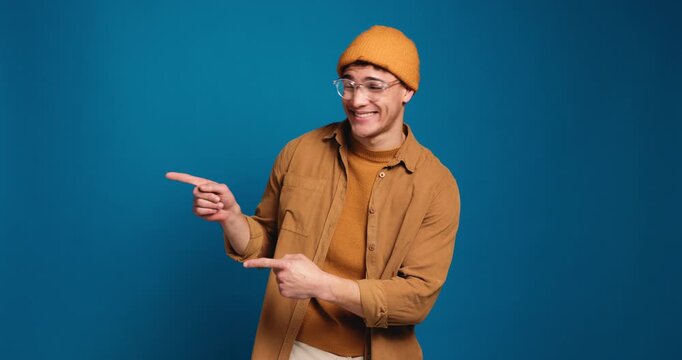 Happy man, face pr pointing with fashion in studio for marketing or option on a blue background. Portrait, male person or model with smile or showing list for selection or advertising on mockup space
