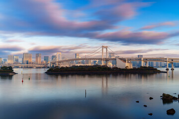 Skyline of Tokyo Rainbow Bridge in morning sunlight under blue sky with cloud