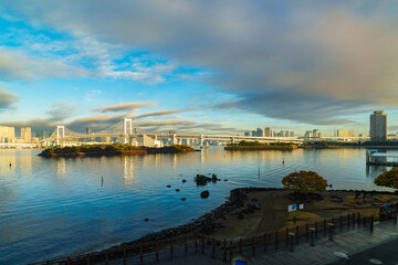 Skyline of Tokyo Rainbow Bridge in morning sunlight under blue sky with cloud