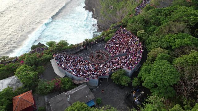 Aerial Drone footage of Ulluwatu Temple and audience watching Kecak Dance during sunset